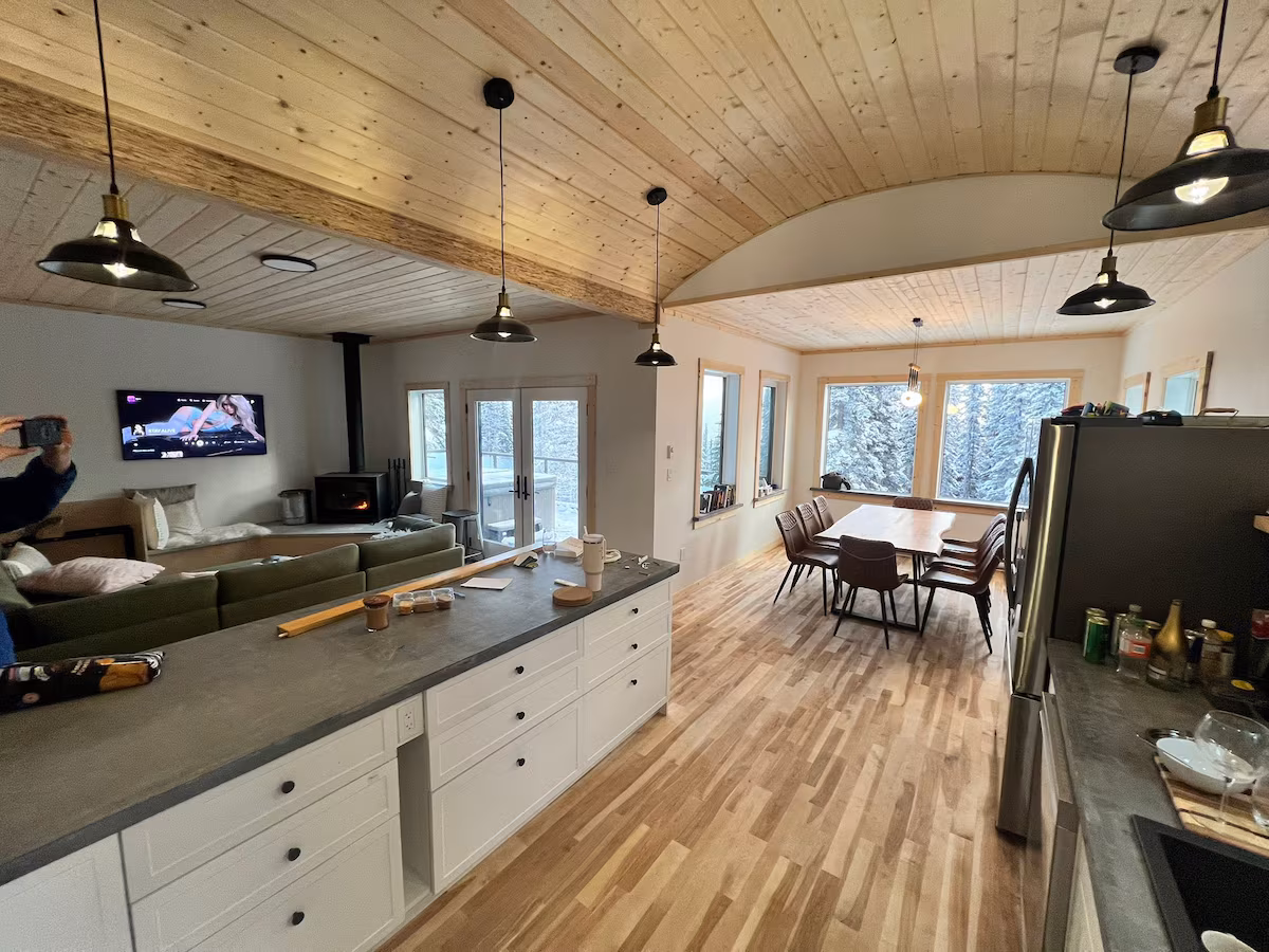 Living room with wood stove and floor-to-ceiling windows at Double Black Retreat